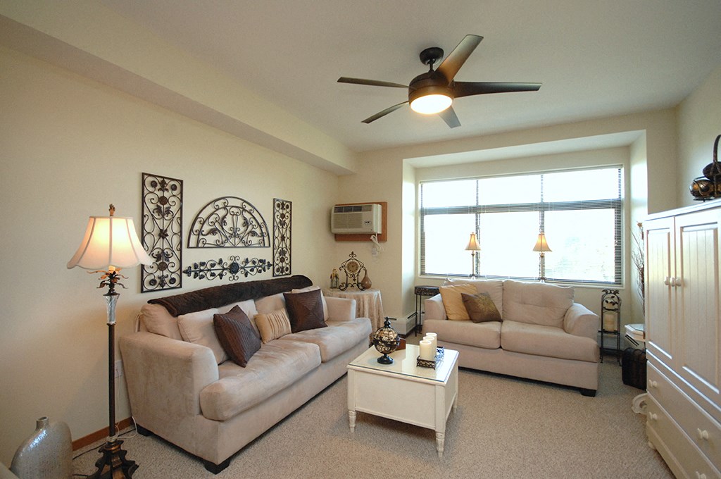 a living room with two couches and a ceiling fan