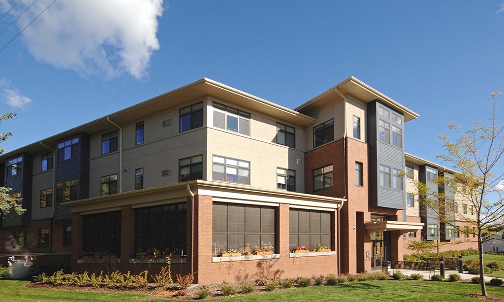 a large apartment building with a blue sky in the background
