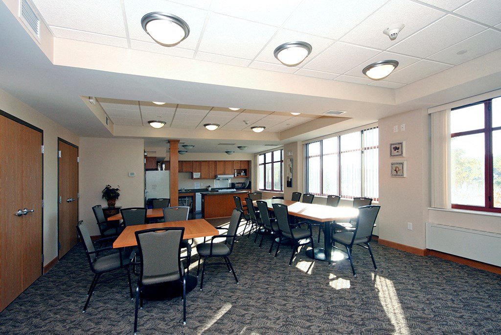 a conference room with tables and chairs and a kitchen