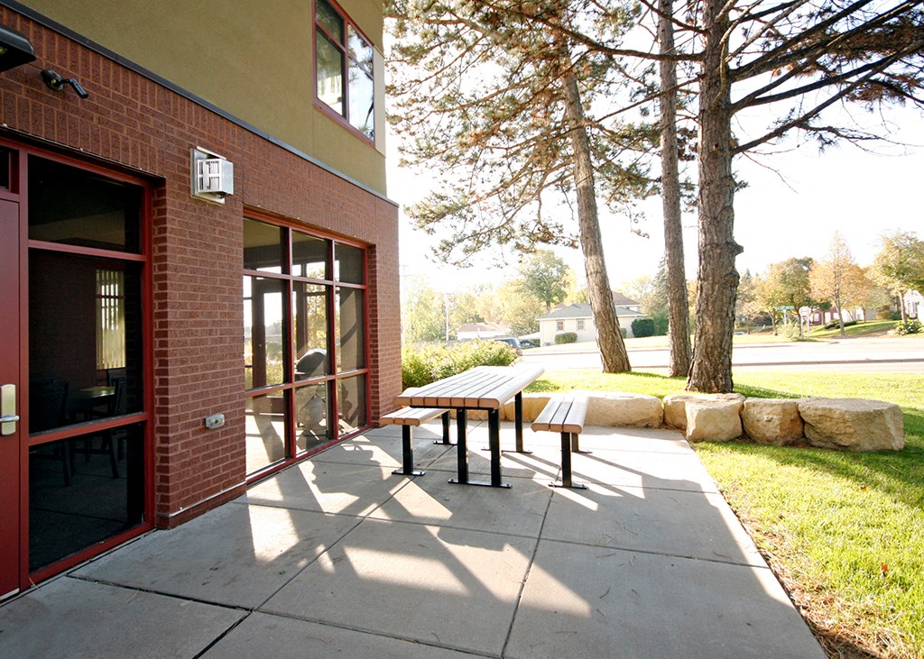 a sidewalk in front of a building with a picnic table