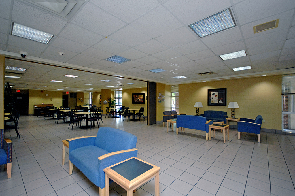 a lobby with blue chairs and tables in a large room