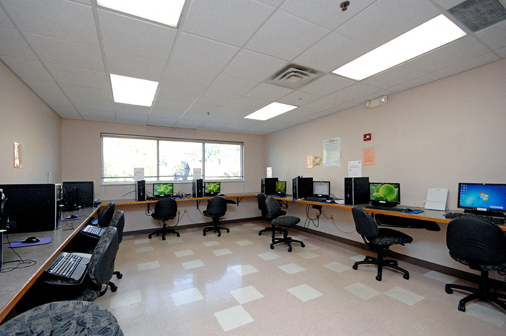 a large room filled with desks with computers and chairs
