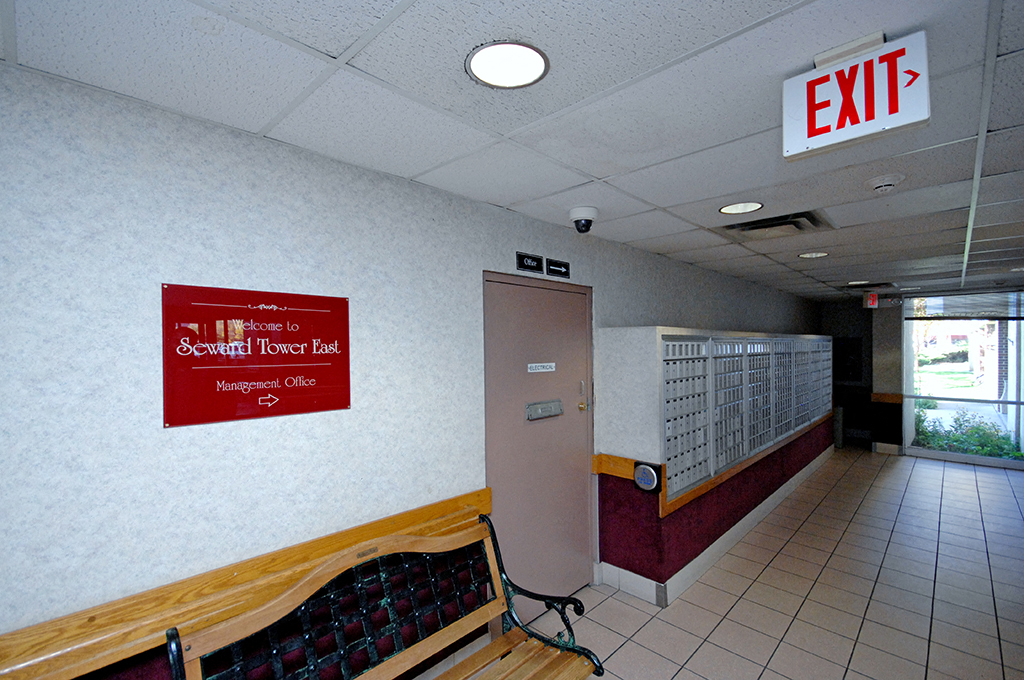 a sign for an exit and a bench in a hallway of a building