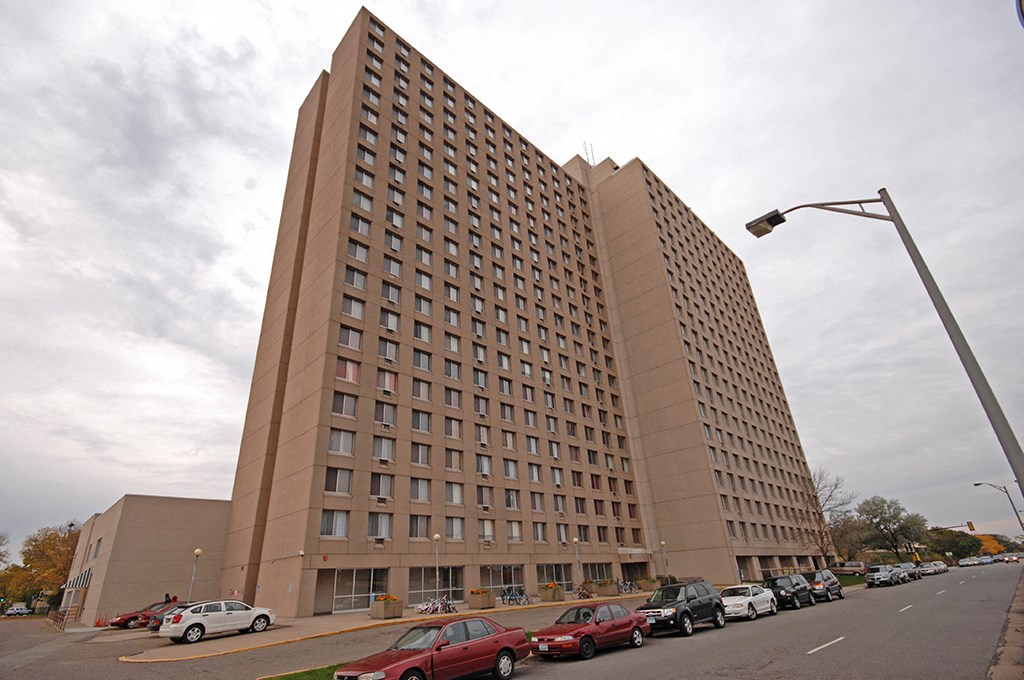 a tall building with cars parked in front of it