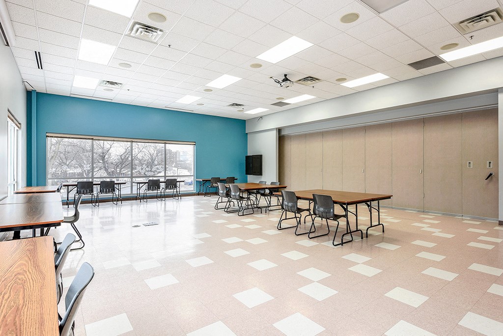 a large room with tables and chairs and a large window