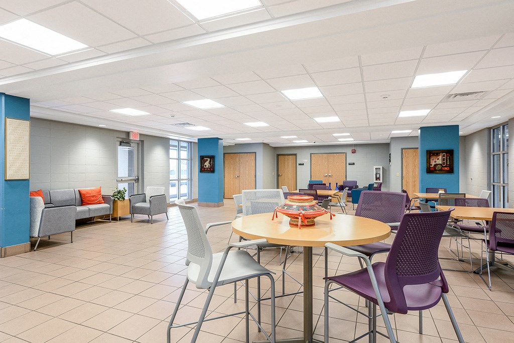 a common area with tables and chairs in a hall