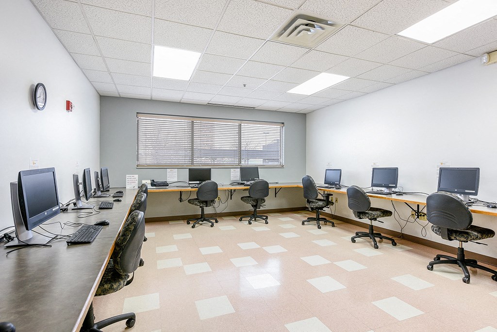 a classroom with desks and chairs and computers in it