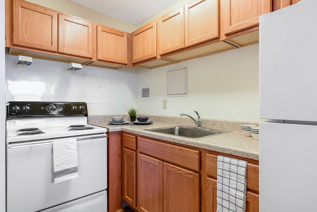 a kitchen with white appliances and wooden cabinets