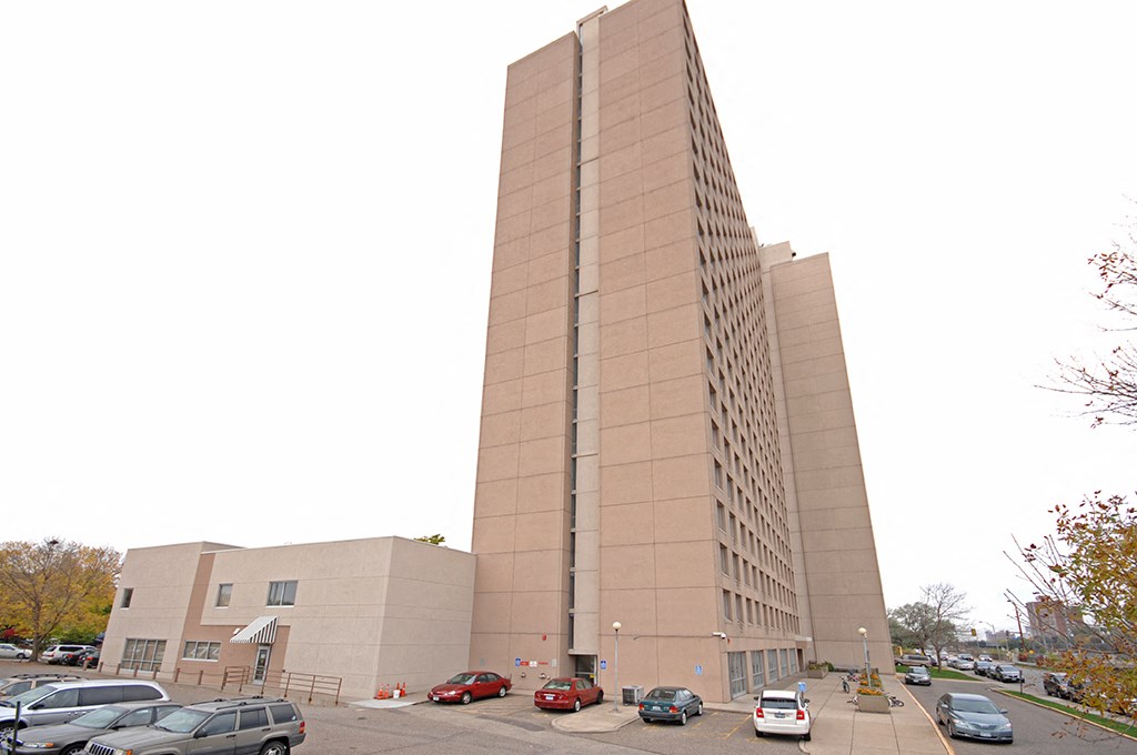 a tall building with cars parked in a parking lot