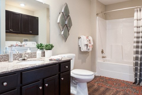 A bathroom with a white toilet and a shower with a striped shower curtain.