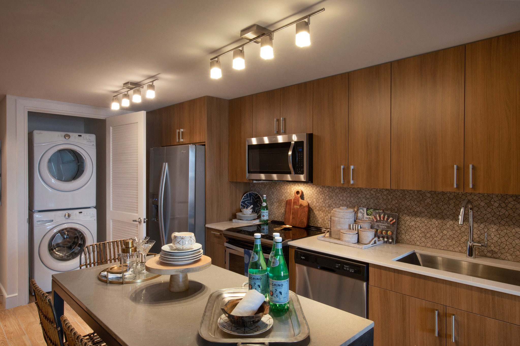 a kitchen with a washer and dryer and a table with plates on it