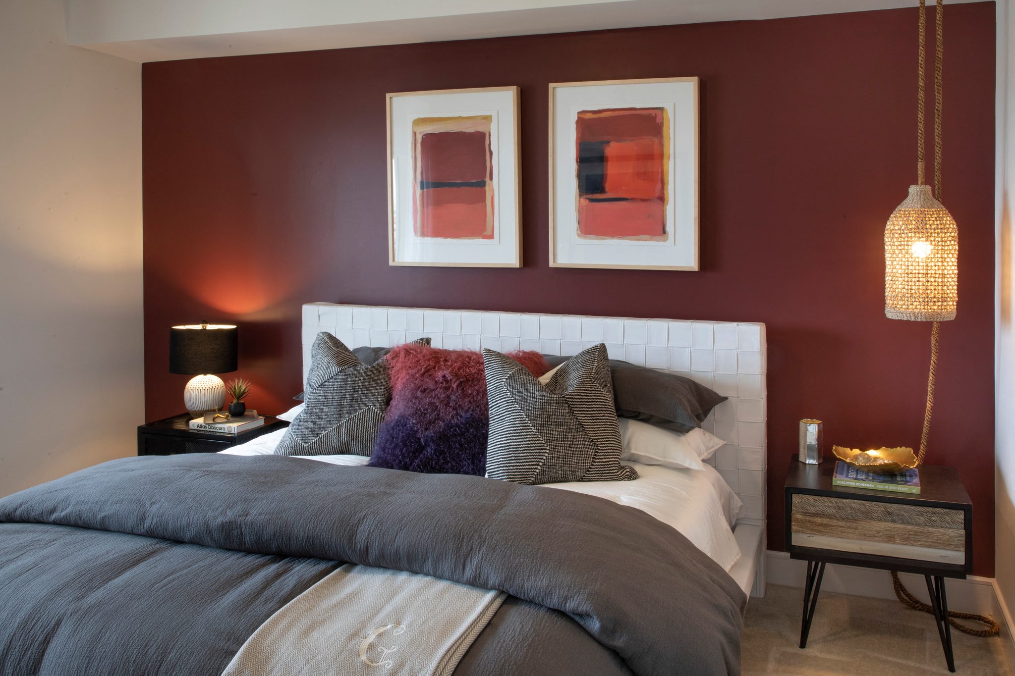 a bedroom with red walls and a bed with pillows