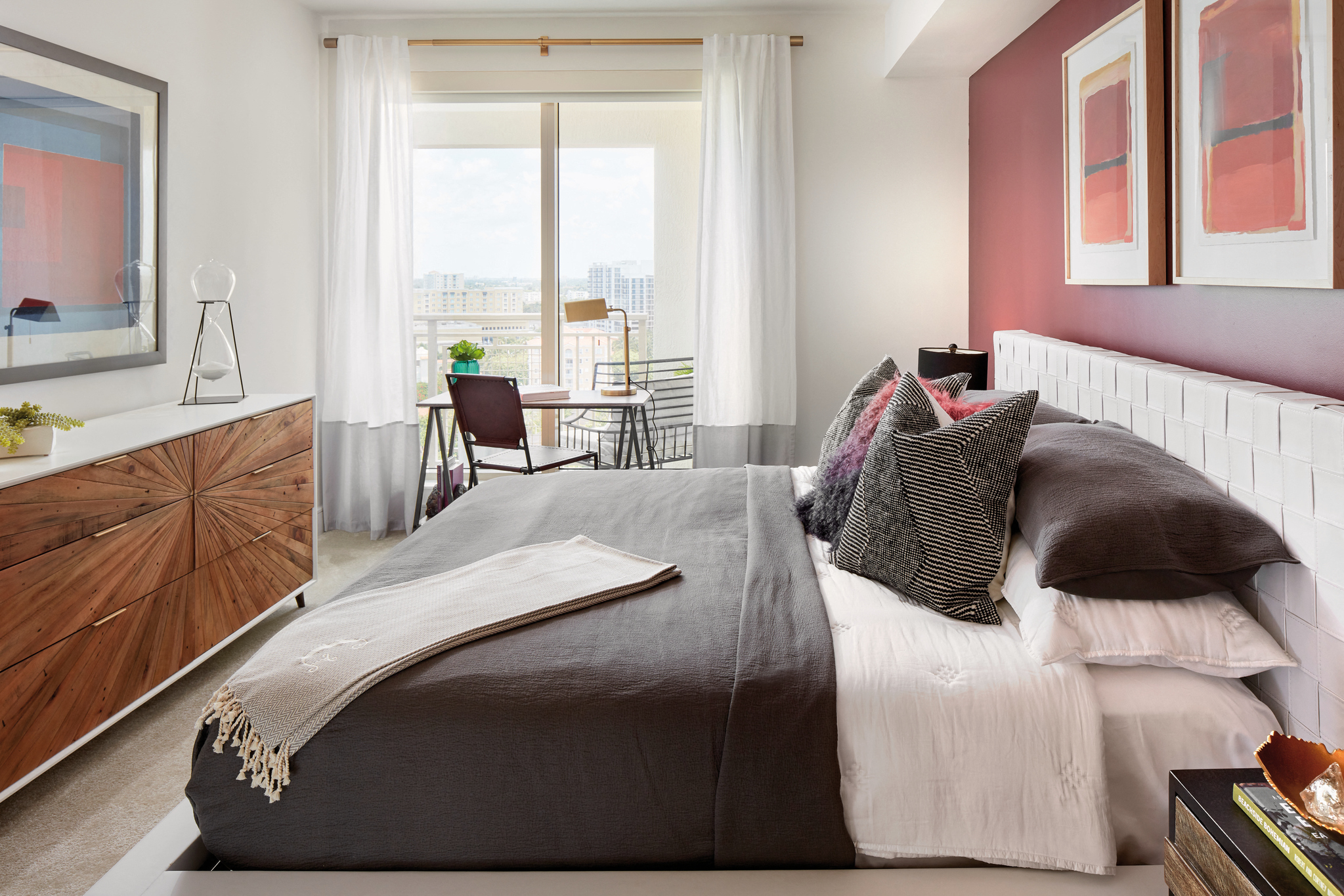 a bedroom with a bed and a pink accent wall
