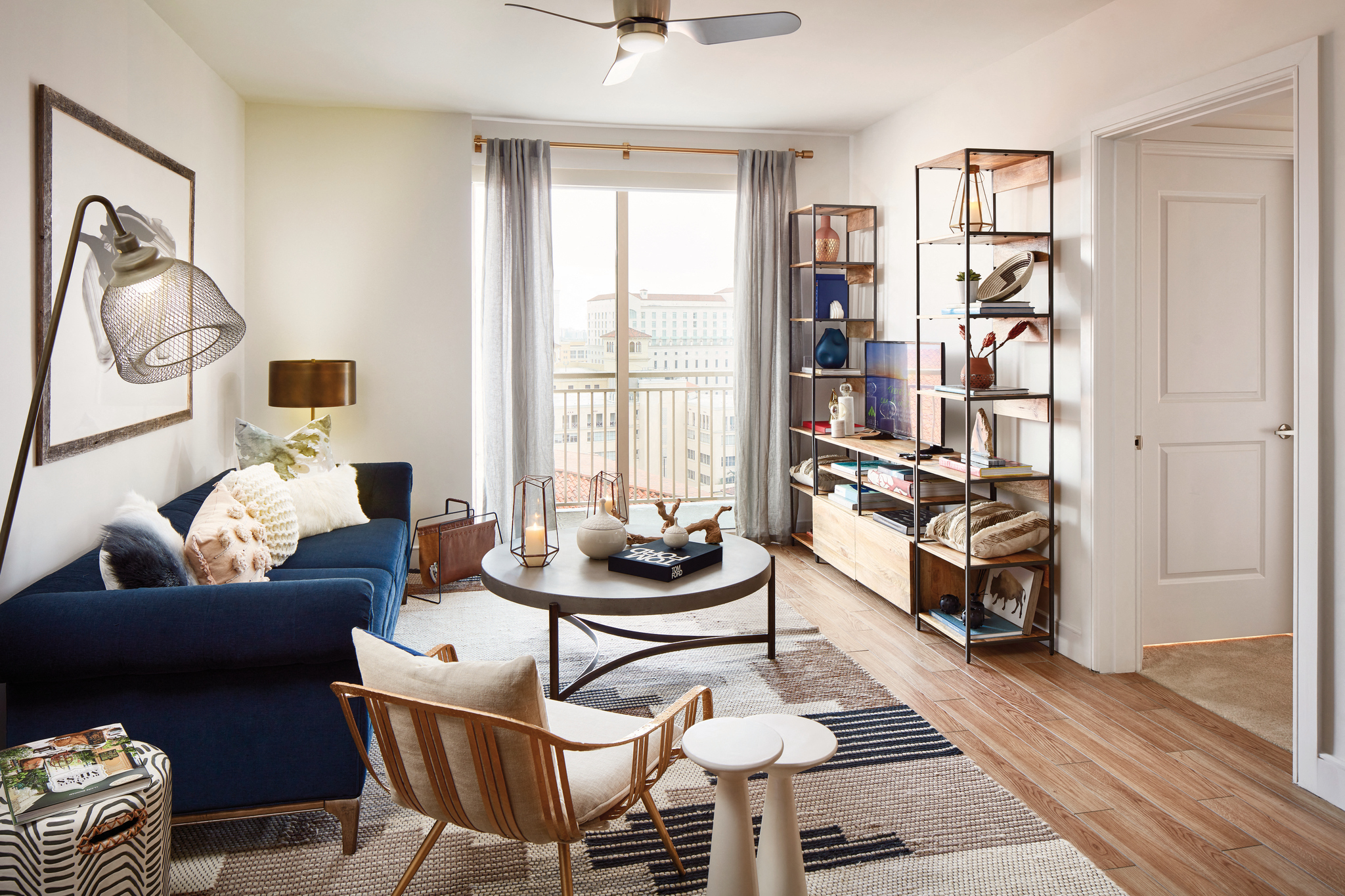 a living room with a blue couch and a sliding glass door