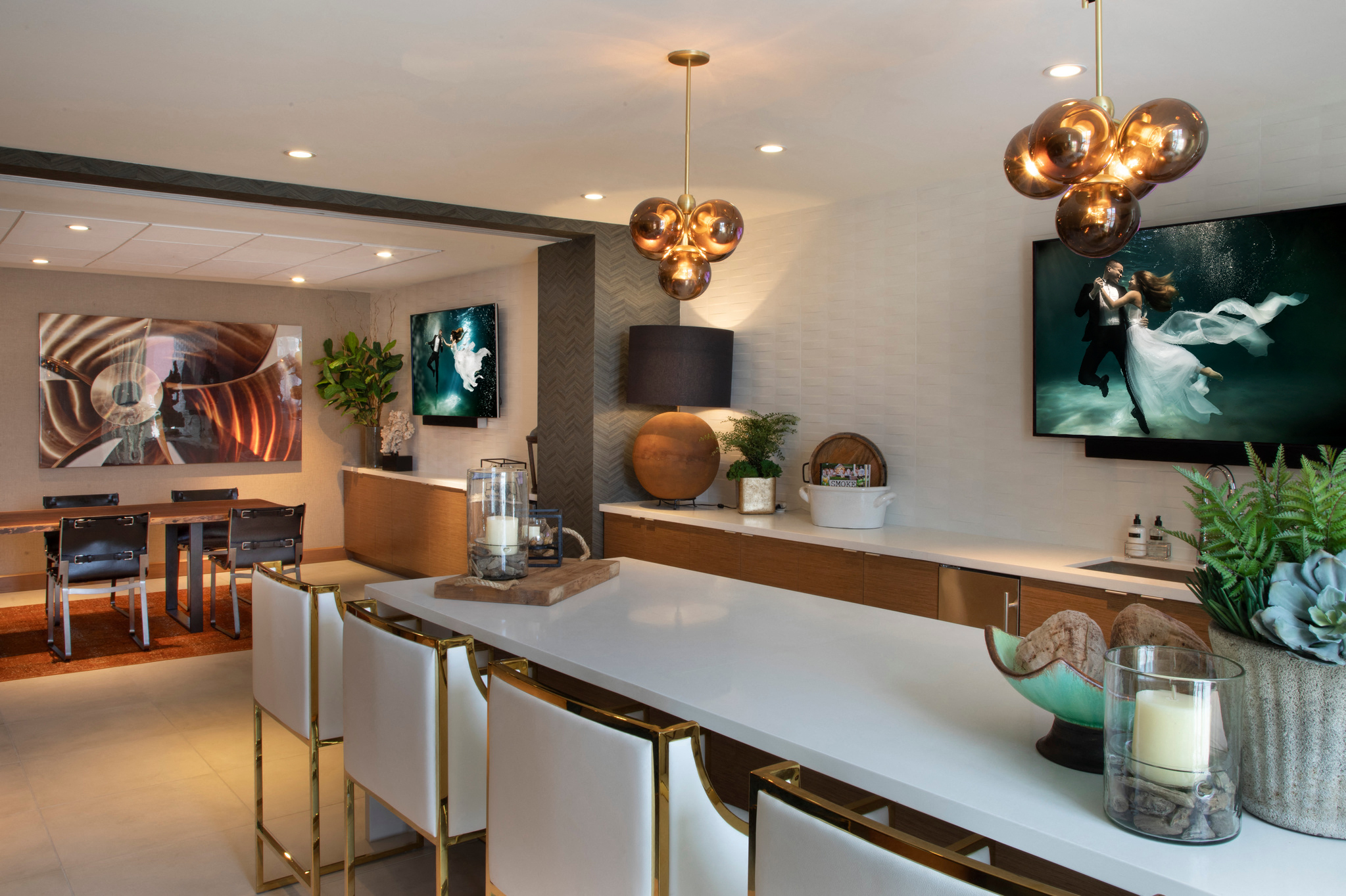 a kitchen with a long counter and white chairs