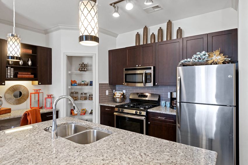 Kitchen with stainless steel appliances and pantry at Atley on the Greenway Apartments in Ashburn, VA - Photo Gallery 1