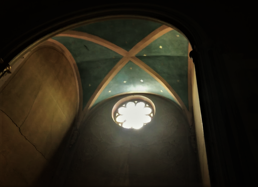 the ceiling of a church with a light in it