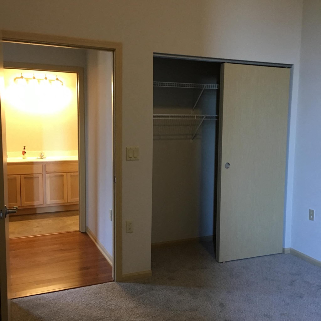an empty bedroom with a closet and a bathroom