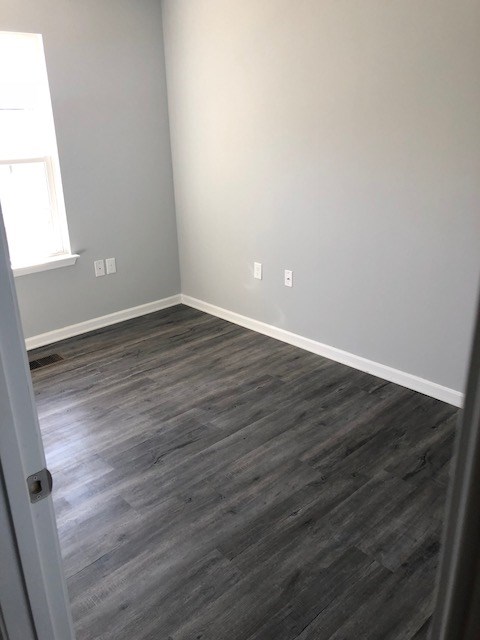 an empty room with wooden floors and a window