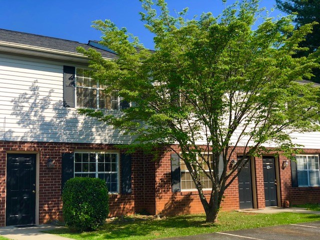 a brick house with a tree in front of it