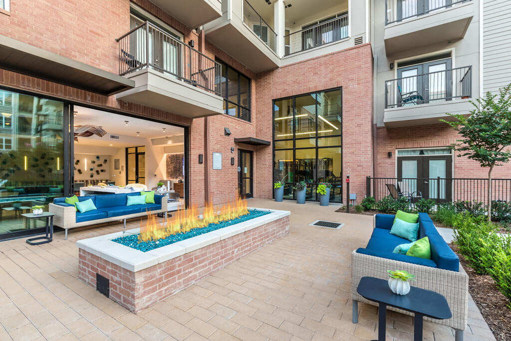 Inwood Station Apartments - Fire Feature with Bench Seating Surrounded by Inwood Station Building