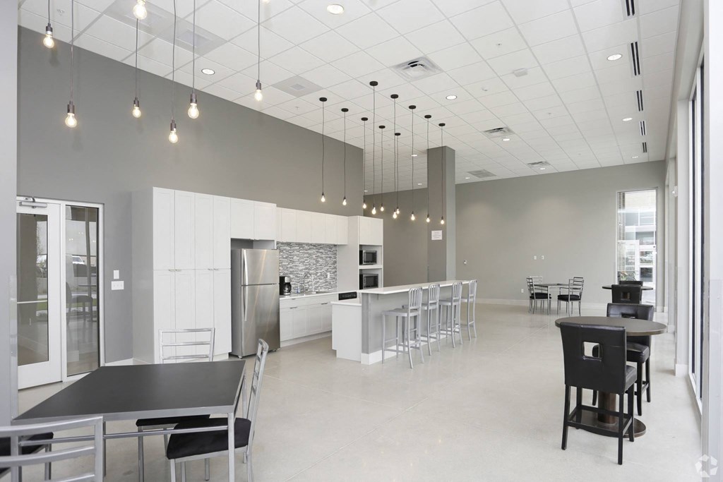 a large room with a kitchen and tables and chairs