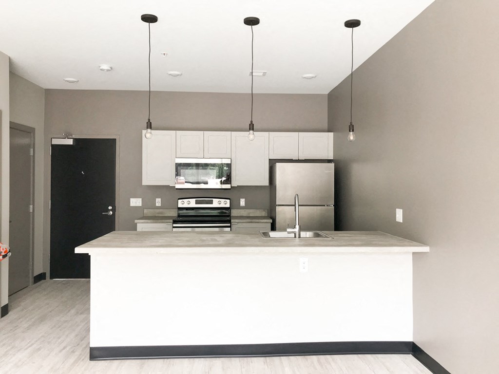 a kitchen with a white counter top and a refrigerator