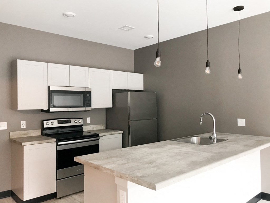 a kitchen with stainless steel appliances and a marble counter top