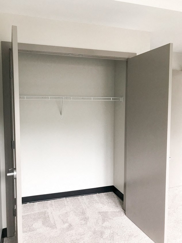 an empty closet in a room with a door open
