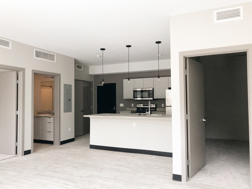 an open kitchen and living room with a white counter top