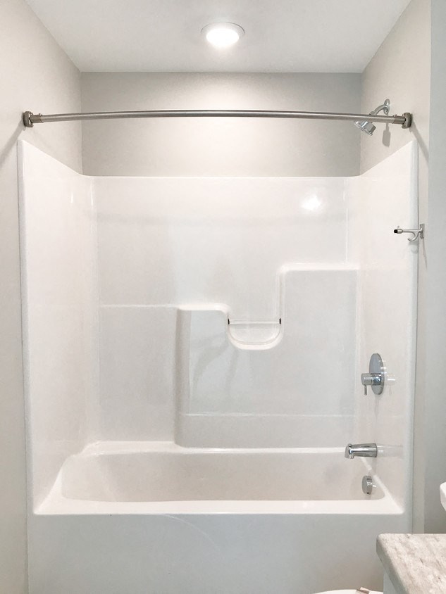 a white bathroom with a shower and a toilet