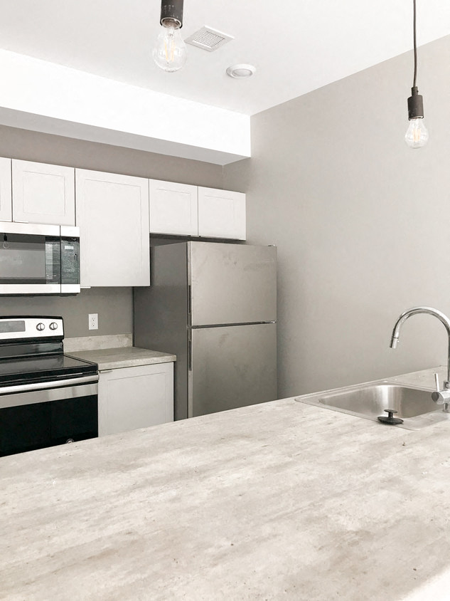 a kitchen with stainless steel appliances and a marble counter top