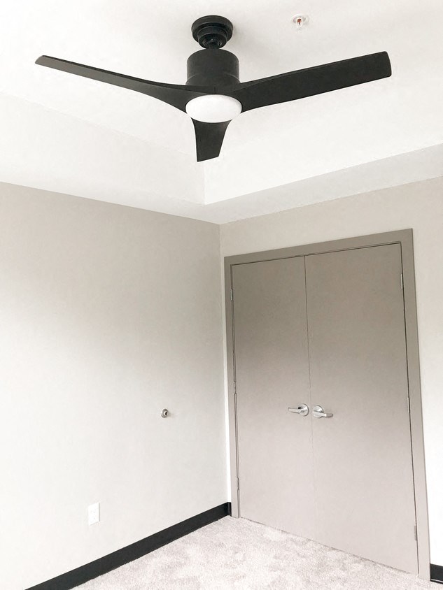 an empty room with a ceiling fan and a closet
