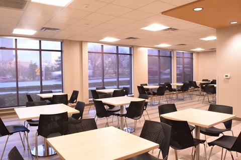 a large dining room with tables and chairs and windows