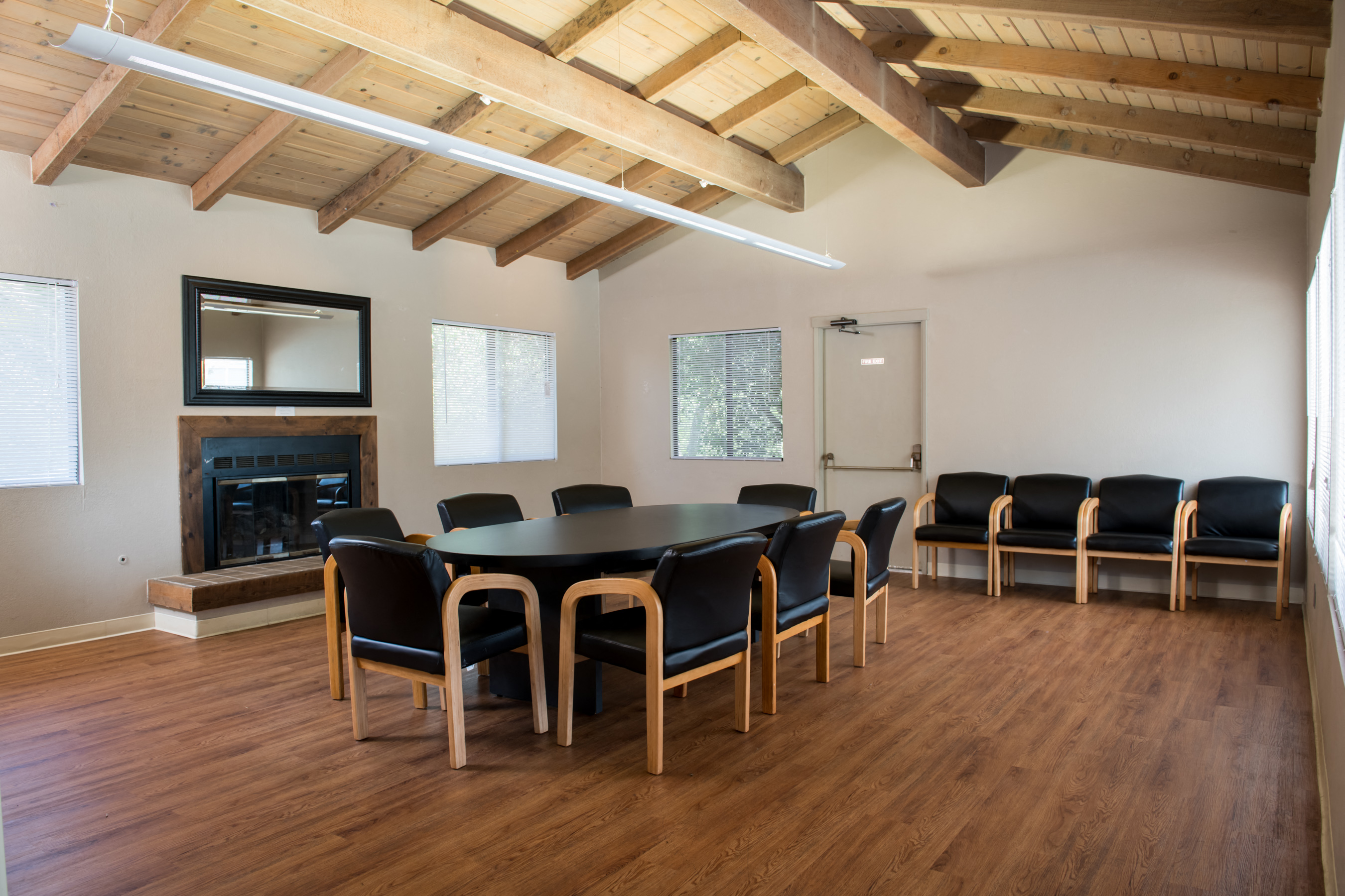 a room with a large table and chairs and a fireplace