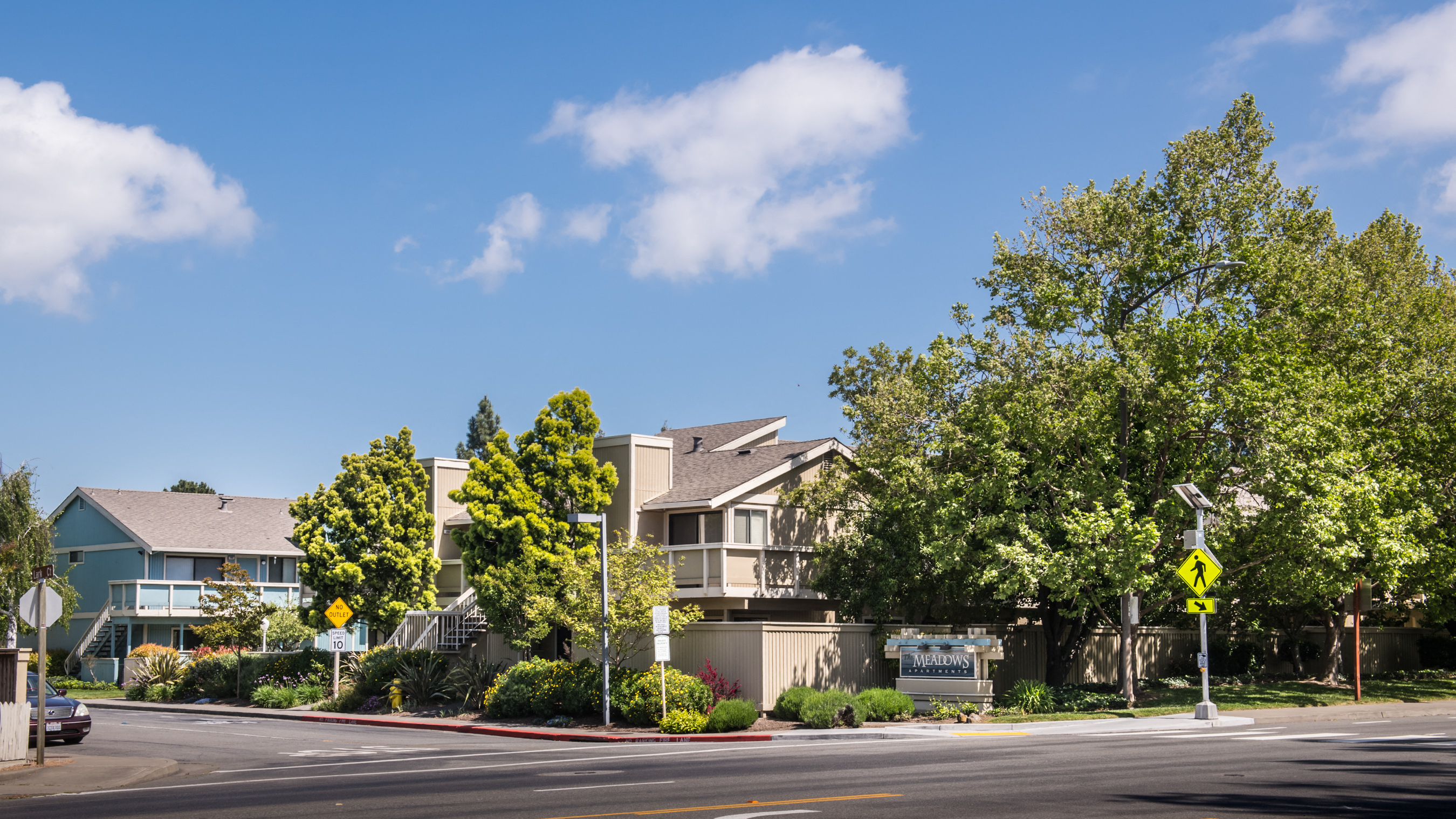 a row of apartment buildings on the corner of a street