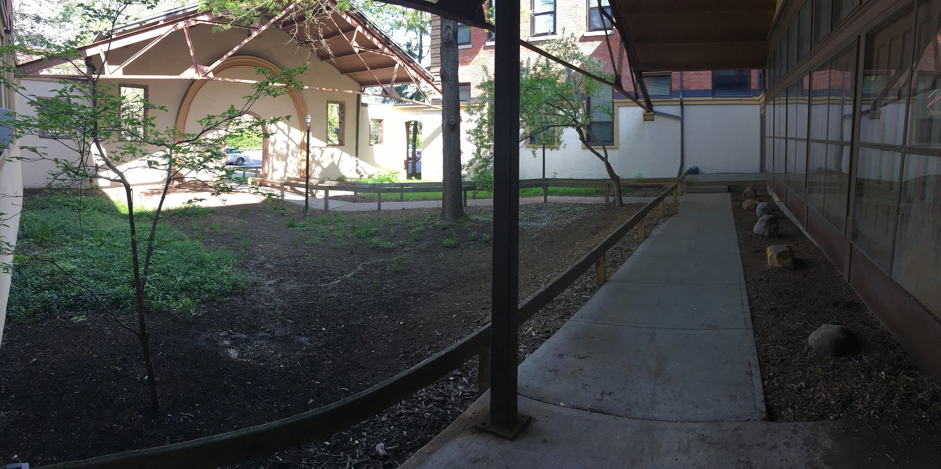 a view of the back yard of a house from the sidewalk