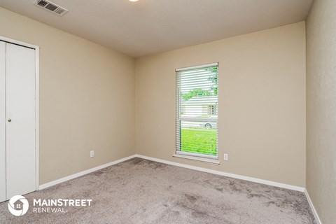 the living room of an apartment with a window and carpet