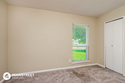 the living room of a home with a window and a door