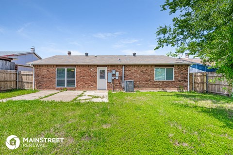 a brick house with a grassy yard and a backdoor