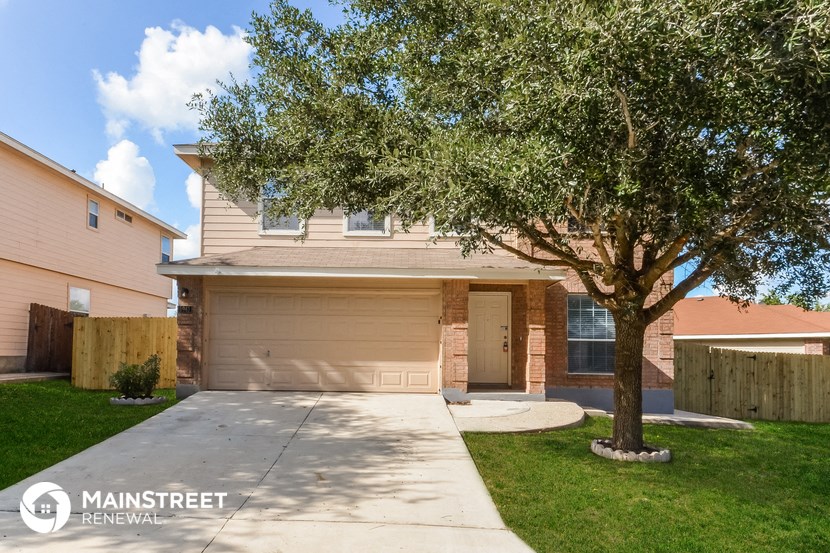 a sidewalk in front of a house with a tree