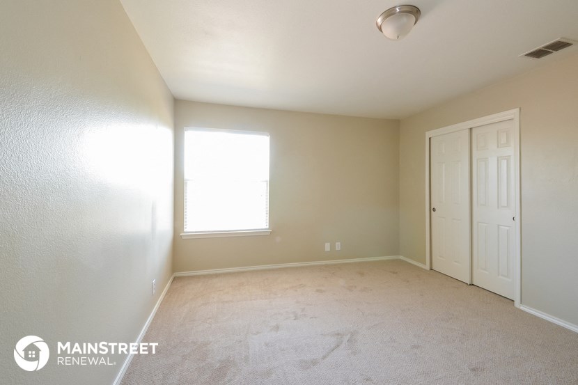 a bedroom with a carpeted floor and a white door and window