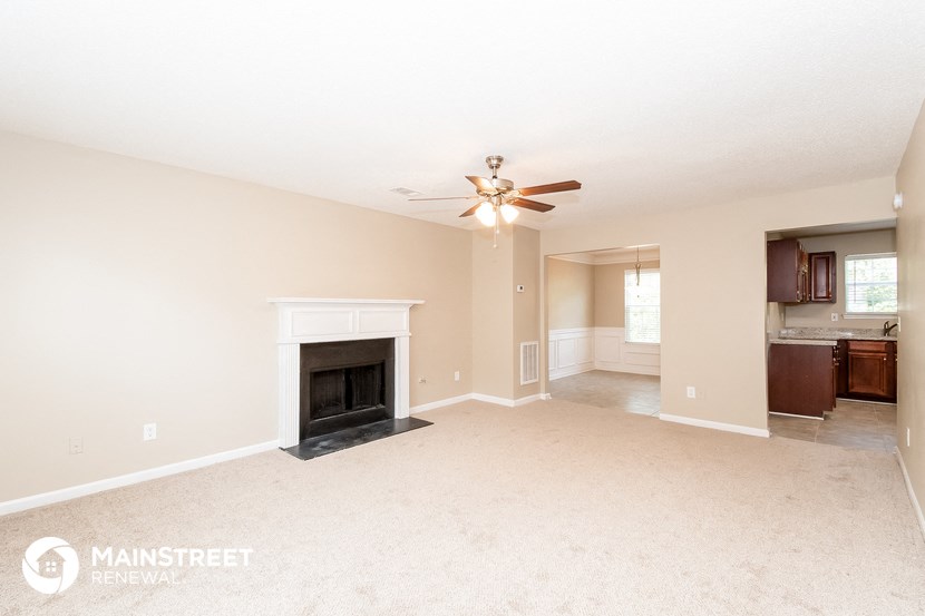 a living room with a fireplace and a ceiling fan