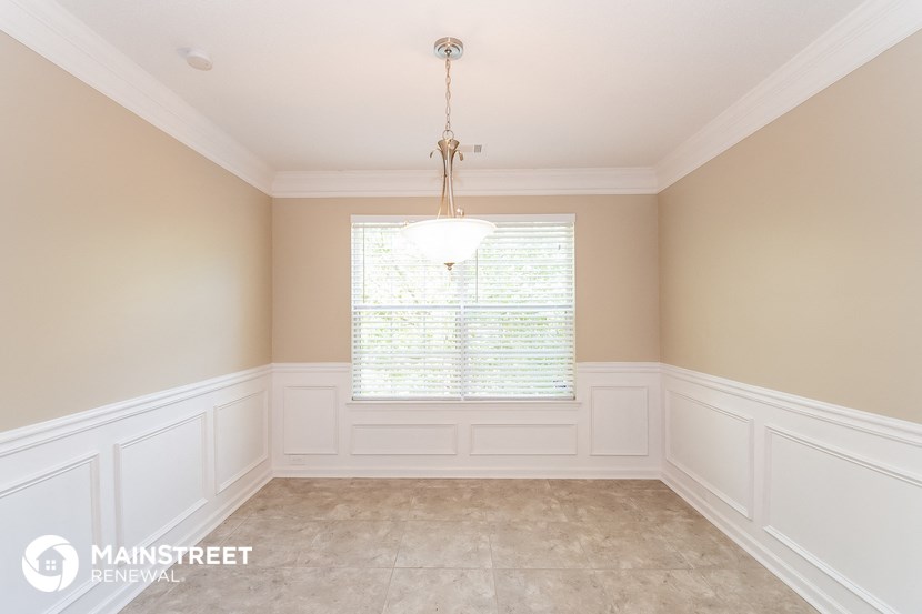 a dining room with white walls and a window