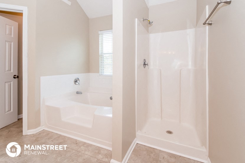 a white bathroom with a tub and a shower