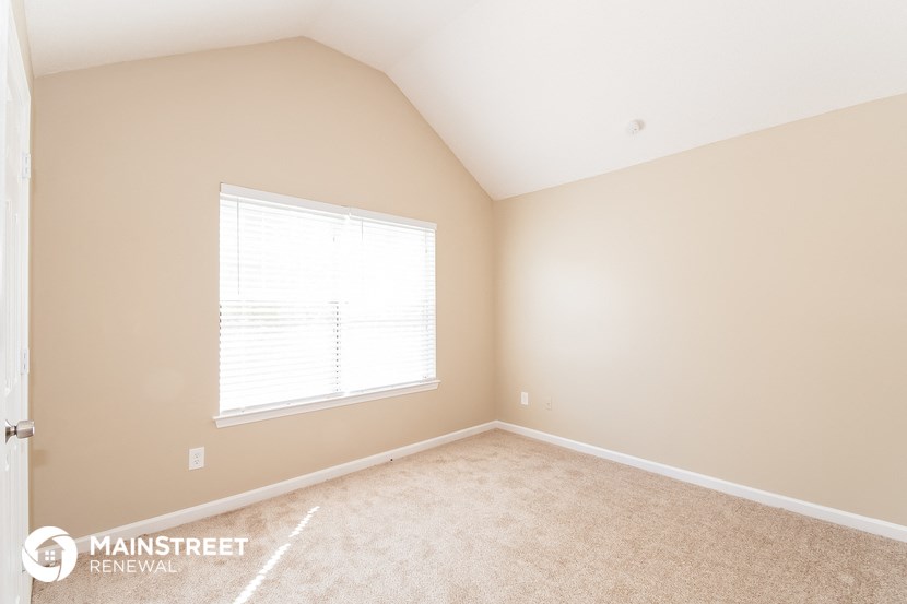 the upstairs bedroom with carpet and a window