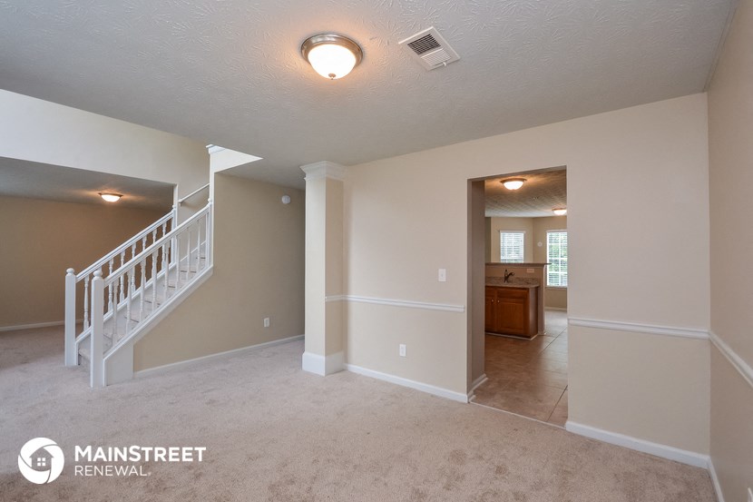 the spacious living room with staircase to the upper level