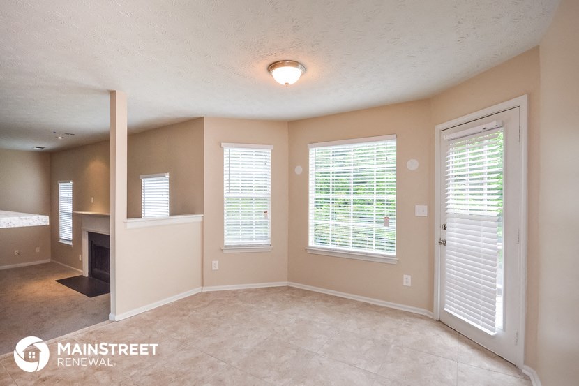 the living room and dining room of a home with a fireplace