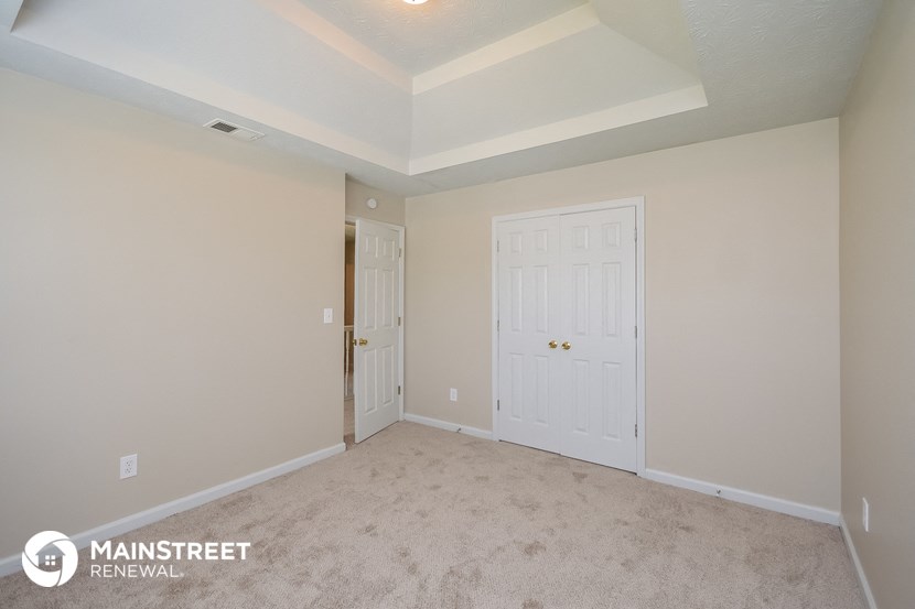 the living room of a new home with white doors and carpet