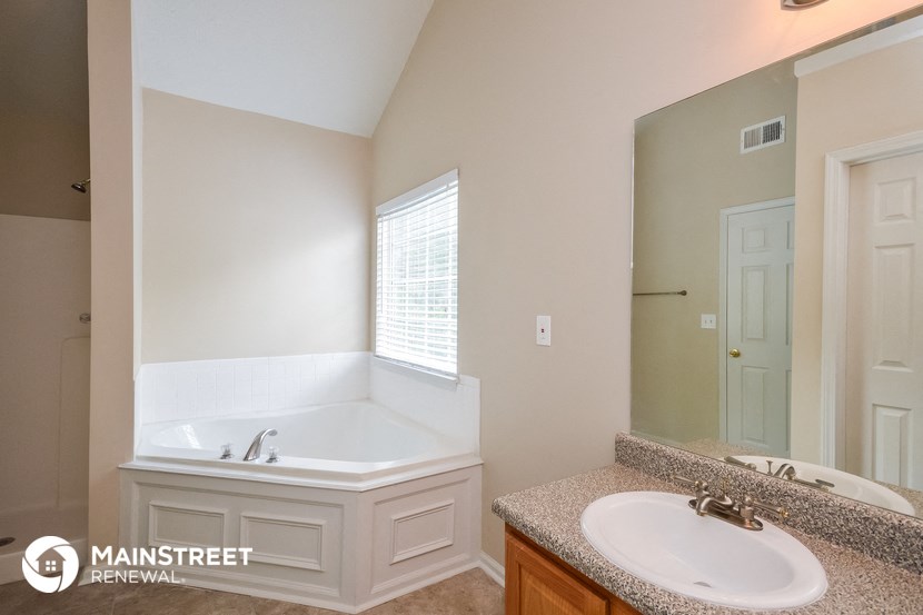 a bathroom with a tub and a sink and a mirror